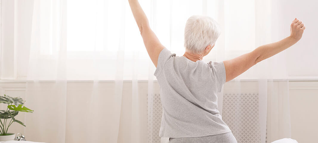 Senior woman stretching after a good nights sleep